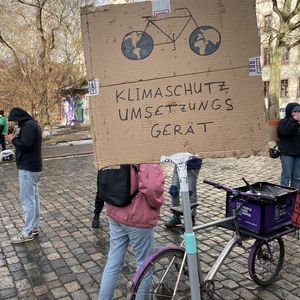 Demo-Schild mit dem Bild eines Fahrrads und dem Schriftzug: Klimaschutz-Umsetzungs-Gerät