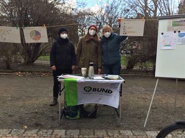 drei Personen mit Maske stehen an einem Stand des BUND Leipzig