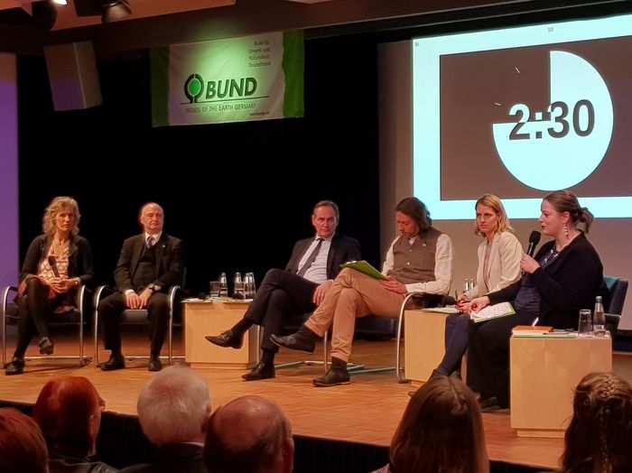 Teilnehmende der Podiumsdiskussion auf Bühne